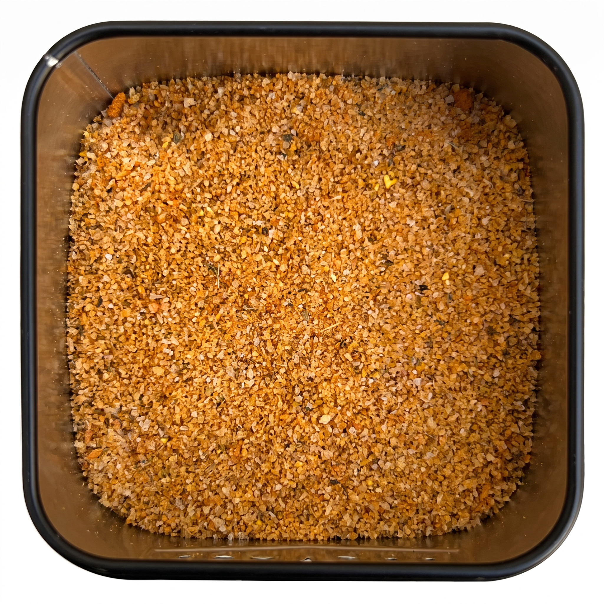 Pommessalz, körnige orange-braune Salzmischung mit Paprika und Kurkuma, in schwarzer Gewürzdose