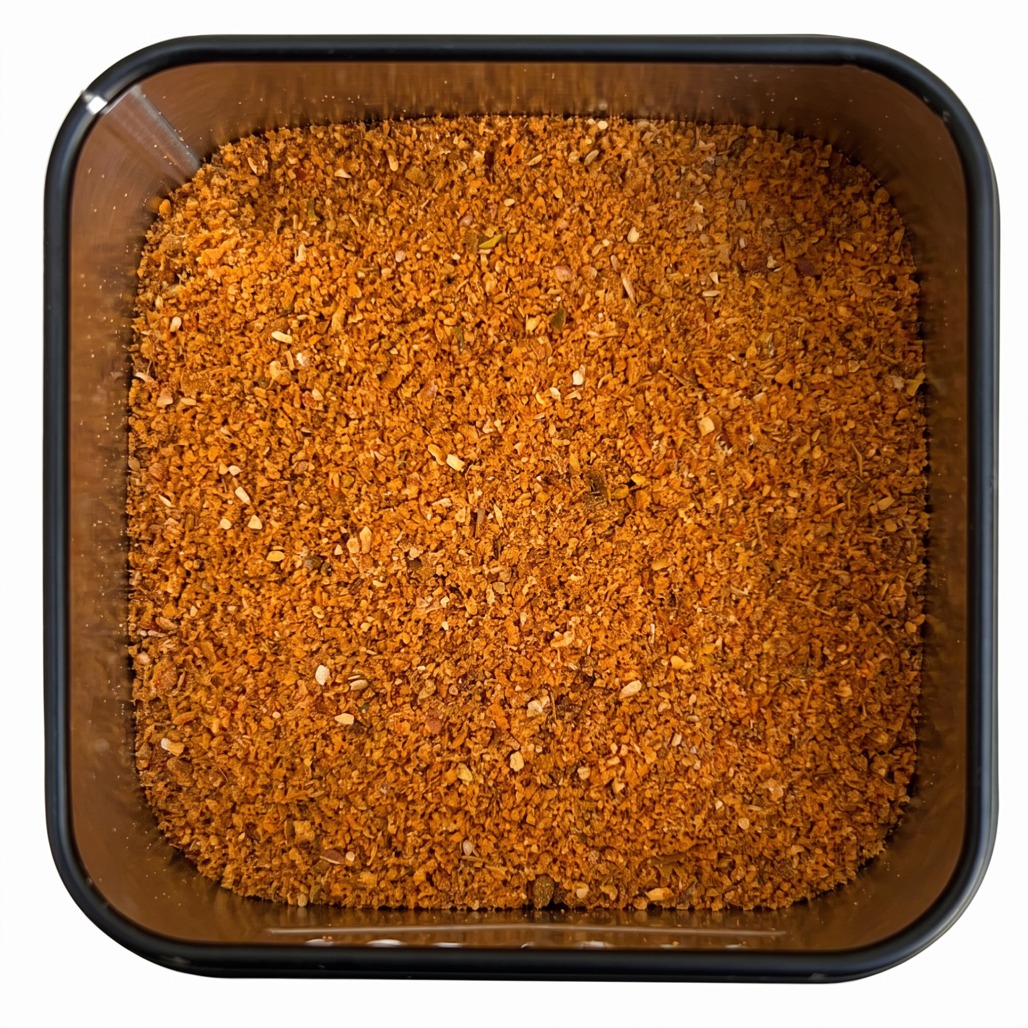 Harissa-Gewürzmischung, kräftig orange-rotes Chilipulver, in schwarzer Gewürzdose, scharf-würzige Note