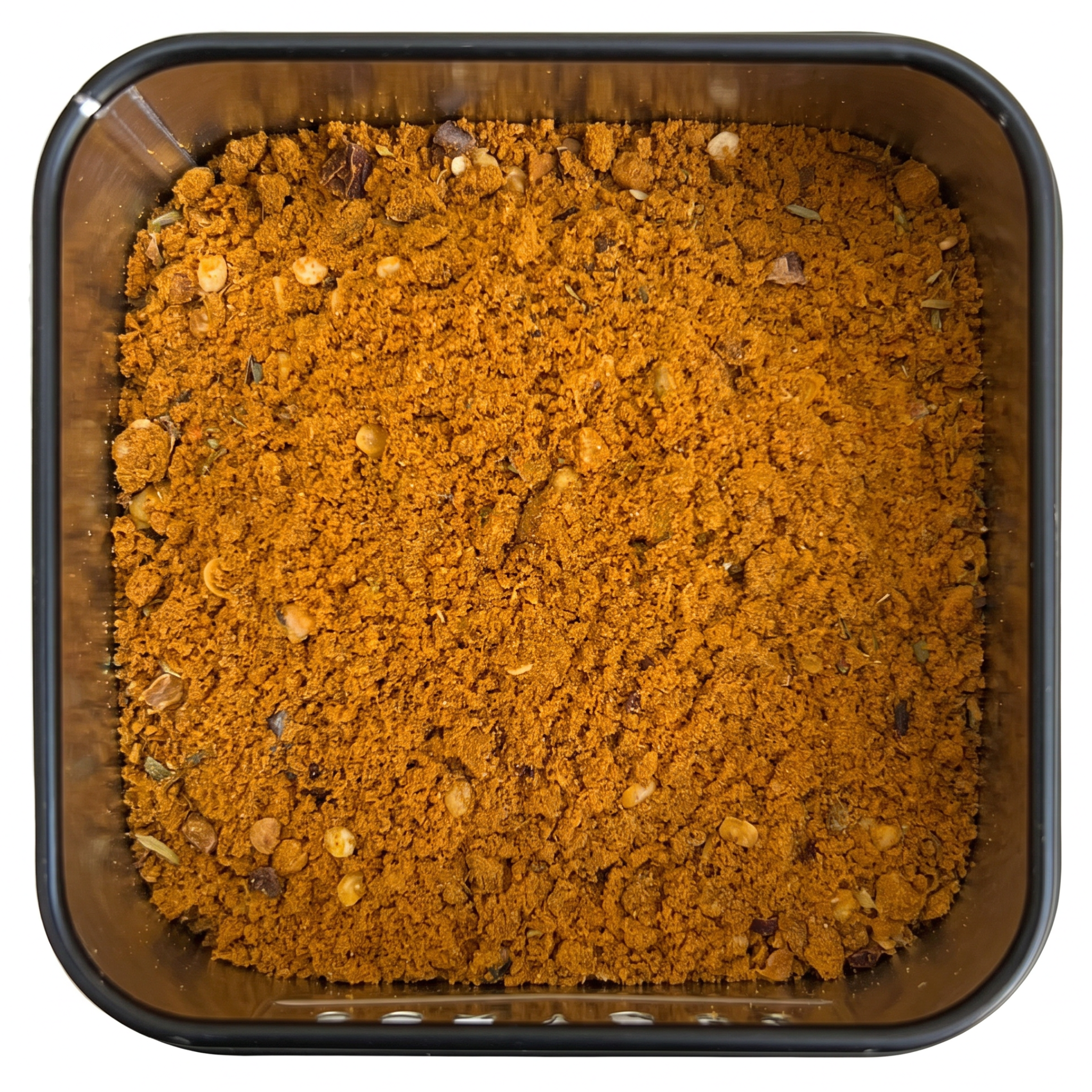 Rajithas Curry, kräftig orange-braunes Currypulver mit Gewürzstückchen, in schwarzer Gewürzdose