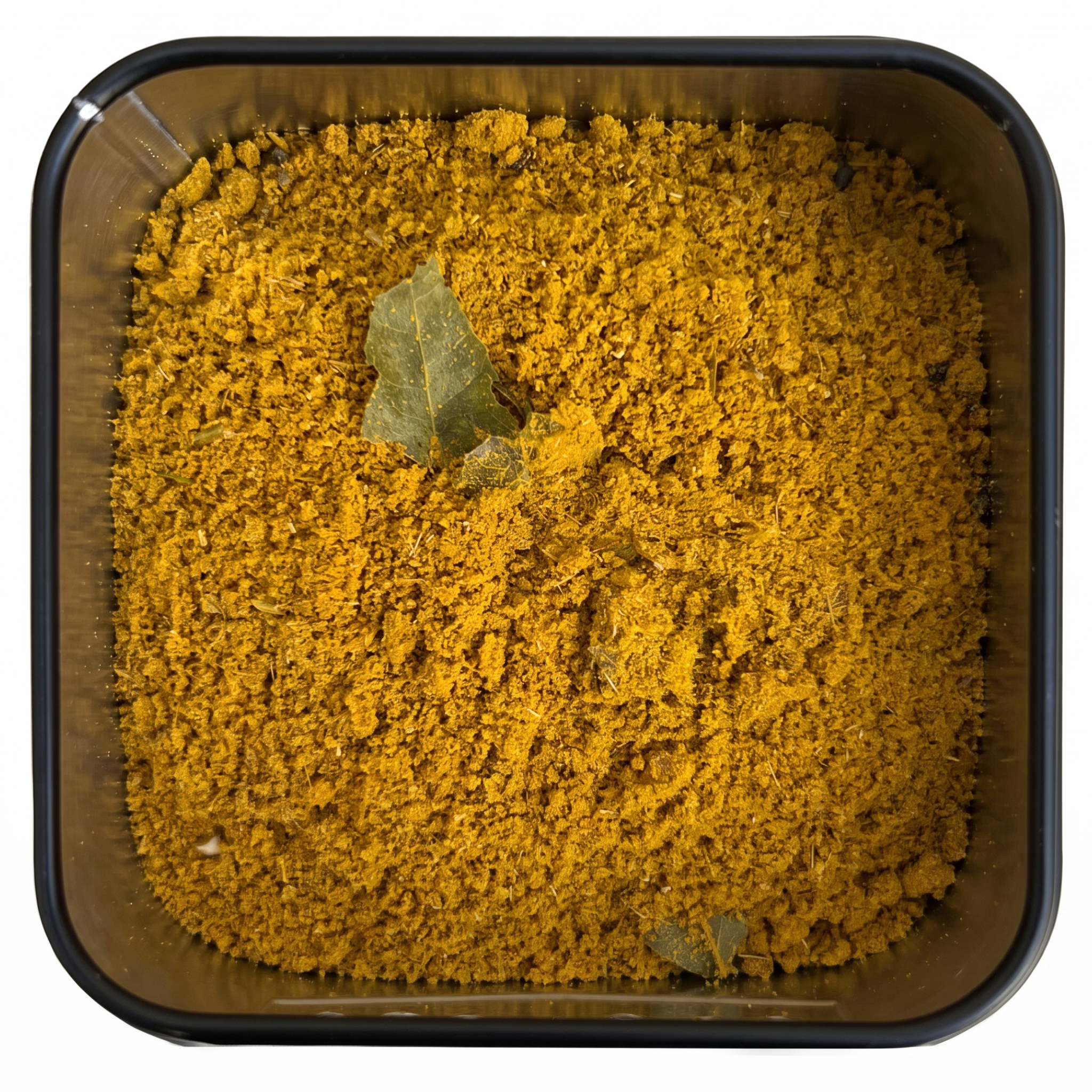 Thayas Curry, kräftig goldgelbes Currypulver mit grünen Curryblättern, in schwarzer Gewürzdose.